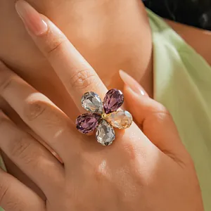 Macro detail of a sparkling multi-colored crystal petal flower ring worn on the finger