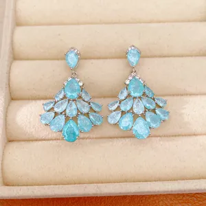 Close-up detail of fan-shaped chandelier earrings with light blue pear-cut zirconia stones.