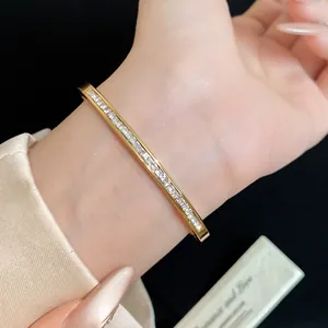 Detailed macro view of a gold stainless steel bangle with white cubic zirconia stones