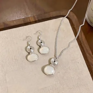 Minimalist ethnic style silver necklace and earrings set with white oval resin pendants