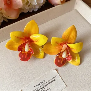 Süße handgefertigte gelbe Orchideen-Ohrstecker aus Stoff und Tropfkleber-Textur