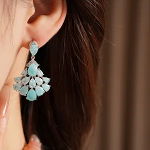 Close-up of 14k gold plated tassel earrings with blue water-drop stones and zircons
