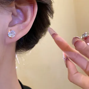 Elegant gold plated cubic zirconia stud earring shown on a model for jewelry detail