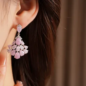 Close-up view of pink zircon water-drop fringe earrings worn on a model's ear