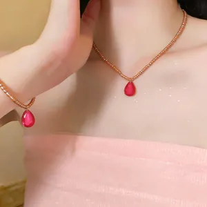 Vue détaillée d'un ensemble collier et bracelet en perles avec pendentifs goutte rose