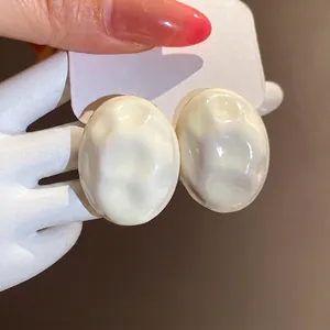 Elegant vintage cream enamel oval stud earrings featuring a unique wrinkled texture design