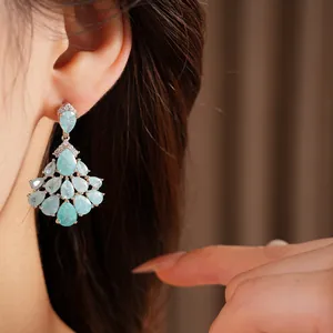 Close-up of elegant 14k gold plated teardrop fan-shaped tassel earrings worn on ear