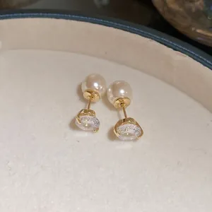 Close-up of elegant gold earrings featuring two-way wear with white pearls and zircons
