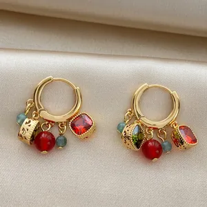 Detailed view of vintage 18k gold-plated hoop earrings with zircon and cat's eye charms