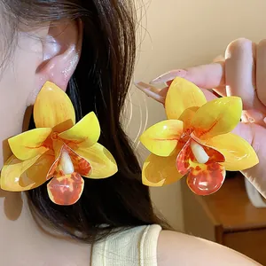 Detaillierte Nahaufnahme süßer gelber Orchideen-Ohrringe mit Harz-Tropf-Kleber-Design
