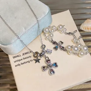 Elegant silver-toned heart cross necklace and pearl bracelet set with colorful zircons