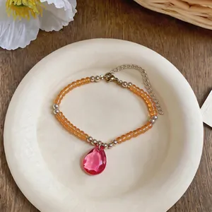 Vue détaillée du bracelet en perles fait main avec pendentif en cristal de goutte d'eau rose