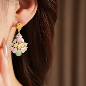 Detailed view of 14k gold plated fan-shaped tassel earrings with colorful zircons