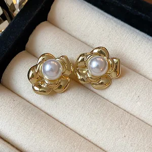 Close-up of elegant gold plated flower pearl stud earrings in vintage style