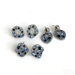 Set di tre paia di orecchini geometrici eleganti con strass blu e finitura in argento.