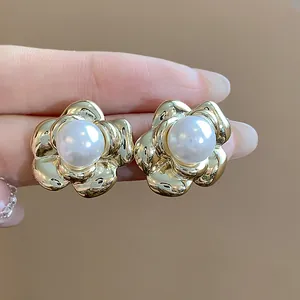Close-up of elegant flower-shaped pearl stud earrings in a French vintage gold finish