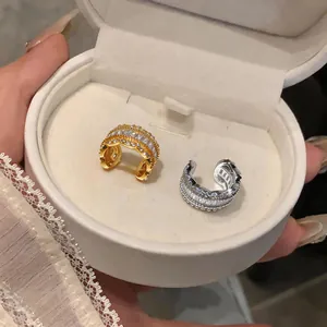 Detailed view of elegant zircon-encrusted C-shaped ear cuffs displayed in a jewelry box
