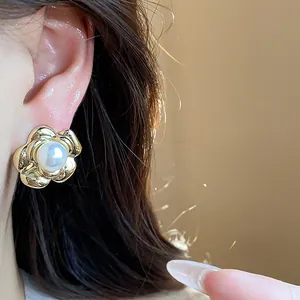 Close-up of elegant French retro flower pearl stud earrings with 13k gold plating