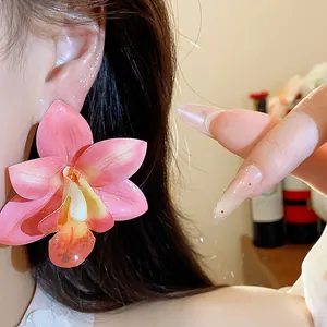 Nahaufnahme von rosa Orchideenblüten-Ohrringen mit zarter Stofftextur und Glanzfinish