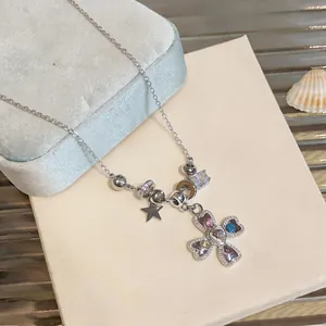 Detail shot of silver necklace featuring colorful zircon heart cross and star charms
