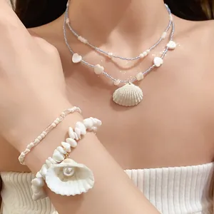Close-up of summer beach blue beaded necklace with shell pendant and matching shell bracelet