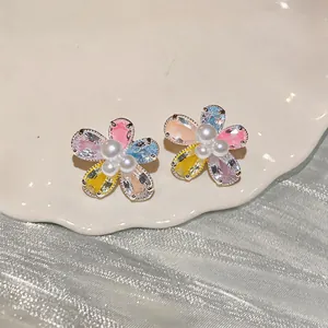 Close-up of sweet flower stud earrings featuring colorful cubic zirconia and pearls