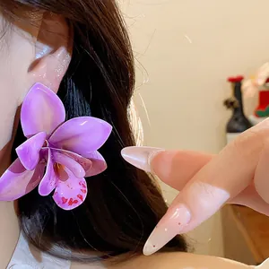 Detailansicht eines eleganten lila Orchideen-Ohrrings mit hochwertiger Silbernadel.