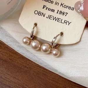 Elegant French vintage style gold hoop earrings with clustered pearls on a cream card