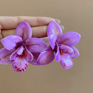 Detailansicht handgefertigter violetter Orchideen-Harz-Ohrstecker mit Silbernadeln