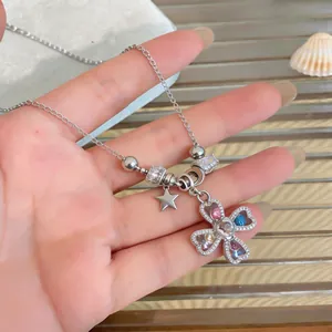 Close-up of heart-shaped clover pendant with colorful zircon stones on silver chain