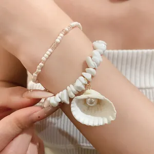 Detailed view of summer style white bead bracelet with shell pearl pendant on wrist