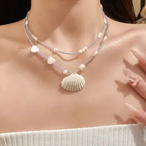 Double layer blue beaded necklace with white shell pendant for beach summer style.