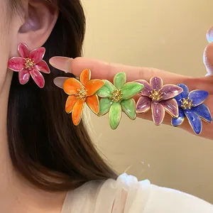 Gros plan de boucles d'oreilles en forme de fleurs colorées de style rétro chic.