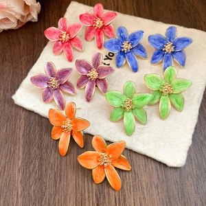 Détail de boucles d'oreilles fleurs en émail de style vintage multicolores