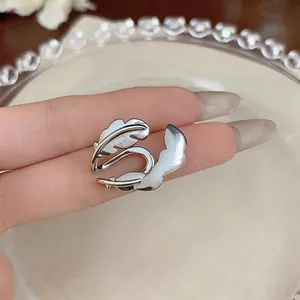 Vue détaillée d'une manchette d'oreille en forme de plume argentée pour oreilles non percées.