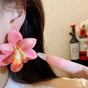 Detaillierte Makroansicht eines eleganten rosa Orchideen-Ohrsteckers aus Harz am Ohr.