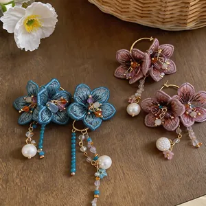 Detailed view of handmade embroidered flower earrings with glass tassels and pearls.
