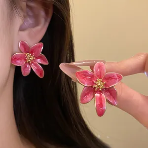 Gros plan de boucles d'oreilles fleur rose de style vintage avec accents dorés