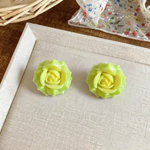 Detailed view of handmade resin flower stud earrings in gradient green and yellow color