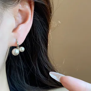 Close-up detail of elegant French vintage geometric double pearl hoop earrings on model