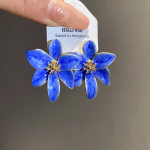 Vue détaillée de boucles d'oreilles fleurs bleues rétro avec centres dorés élégants