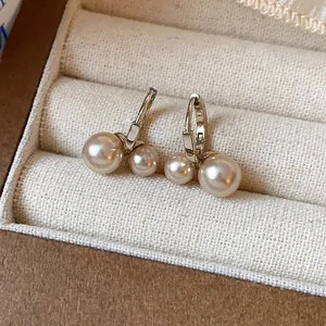 Detail of French vintage gold-toned hoop earrings with elegant double pearl design