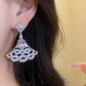 Detailed view of luxury silver fan-shaped chandelier earrings with sparkling zirconia