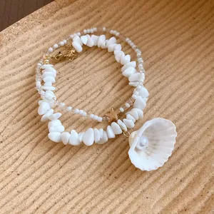 Macro detail of summer beach beaded necklace featuring white shell pendant and starfish