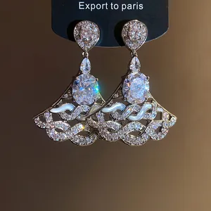Detailed close-up of luxury zircon dangle earrings with elegant wave design accents