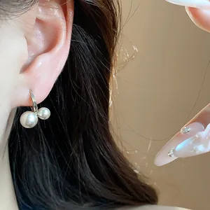 Close-up detail of elegant French vintage style gold hoop earrings with double pearls