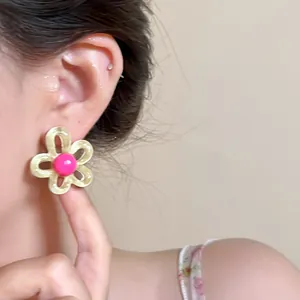 Detailed close-up view of a sweet dopamine style hollow flower stud earring on ear
