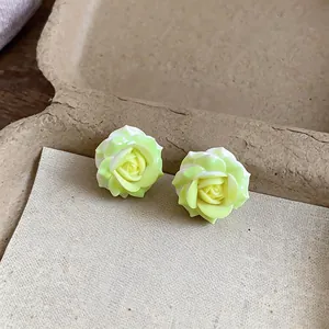 Macro view of light green resin rose earrings showcasing delicate petal textures.
