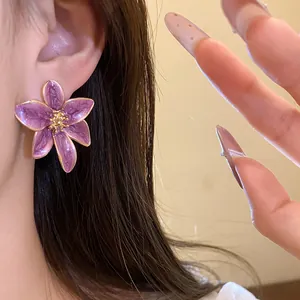 Détail d'une boucle d'oreille fleur en émail violet vintage avec bords dorés élégants
