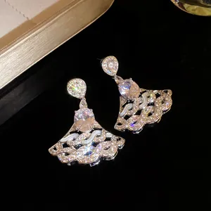Close-up of luxury zircon earrings featuring an oval center stone and scalloped fan design.